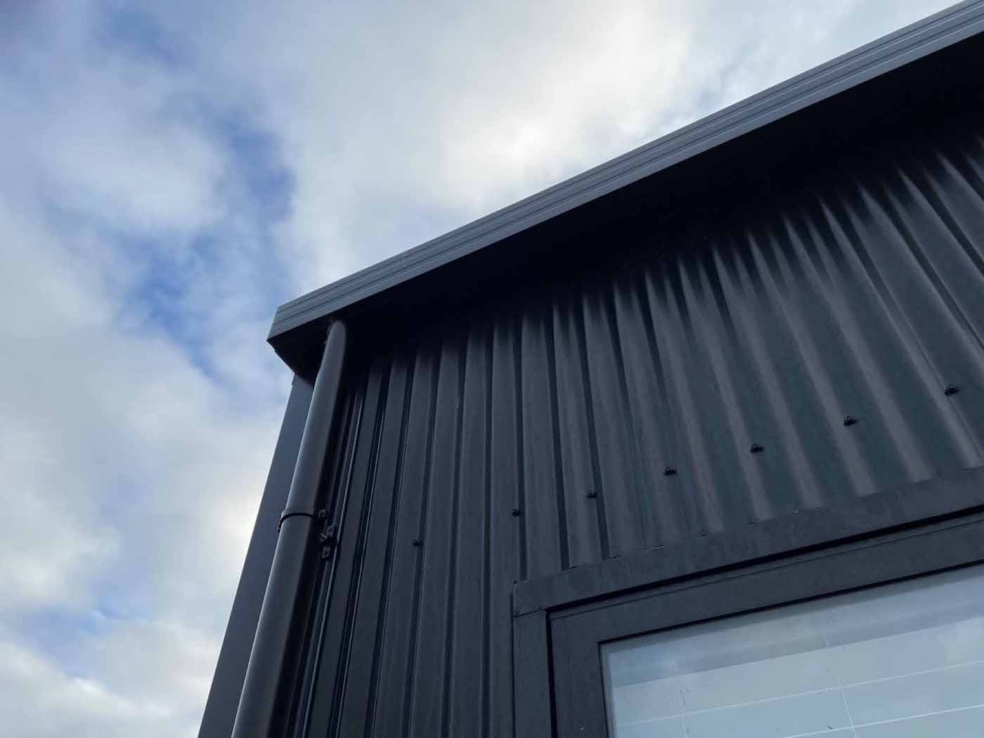 New black downpipe and spouting installed on a modern Christchurch building