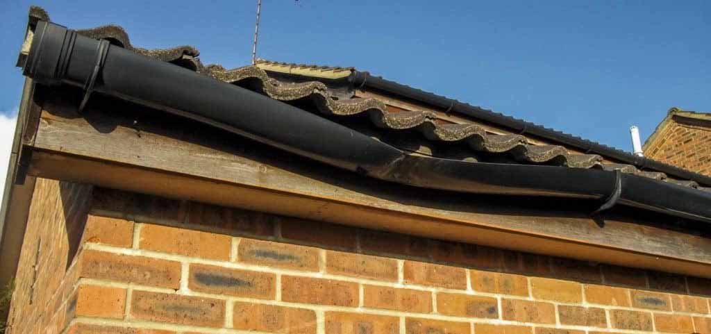 Sagging black spouting on a brick Christchurch home showing loss of gutter fall