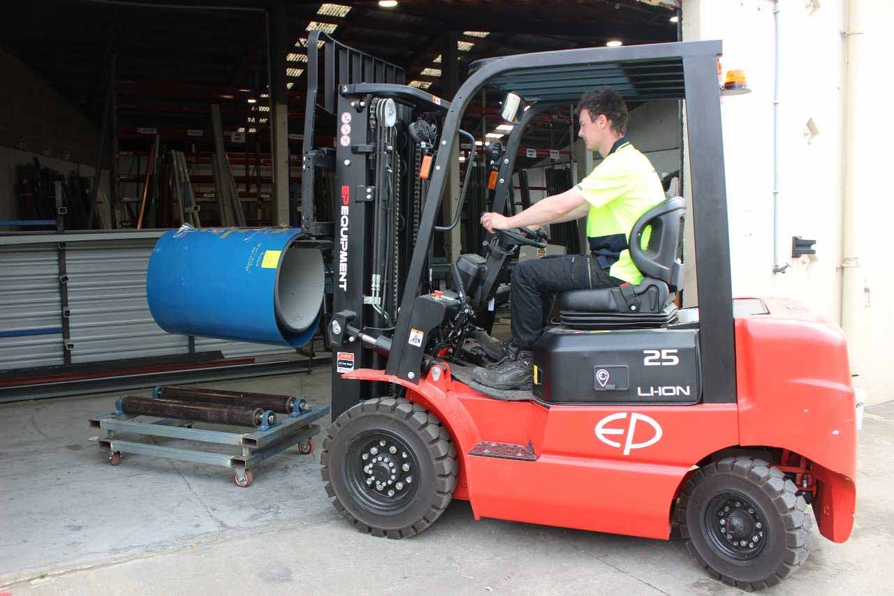 Clearwater Spouting team member moving a metal coil in the Christchurch workshop
